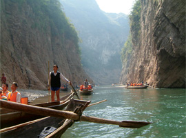 Still image from 2007 movie "Up the Yangtze," wherein a boy with a rod is standing on a boat on a river.