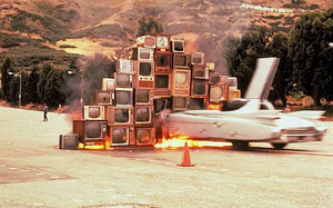 Image of an airplane crashing into a large pile of cargo boxes.