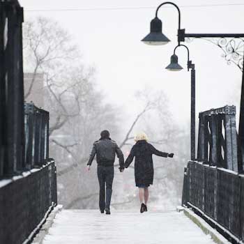 image from the cover of Stories We Tell showing 2 people walking on a snowy bridge