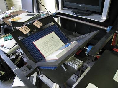 Photo of a book scanner with a book inside, ready to be scanned.