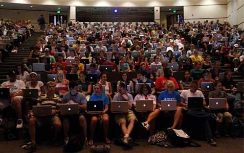 Photo of a lecture hall completely filled with students using Macbooks.