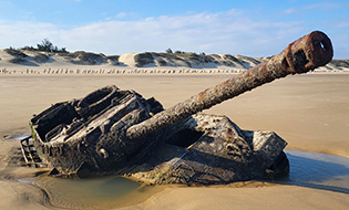 Tank Submerged in Sand on a Beach Photo