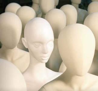 Photo of mostly featureless white plastic figures of human bodies.
