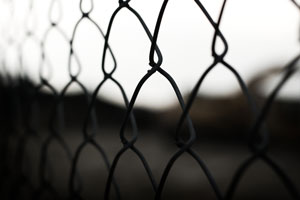 Photo of a prison gate, taken with high contrast and a dreary feel.