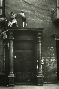 Photo of two children playing on a precarious ledge in New York City.