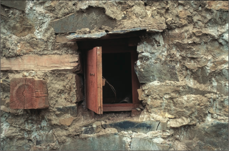 Outer of two windows for passing supplies into a dark retreat.