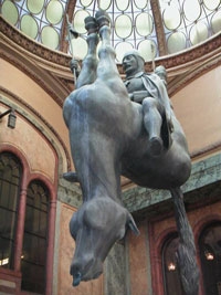 A famous sculpture of a man riding an upside down horse - the man is right-side-up.