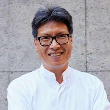 Chenxi Tang Outdoors against Concrete Wall