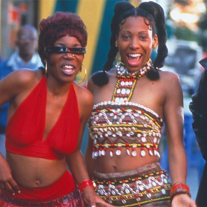 Babymother Film Still, Three Colorfully Dressed Happy Women on Sidewalk