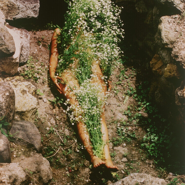(Nude Woman Covered in White Flowers in a Shallow Rock Pit) by Ana Mendieta, Imagen de Yagul, from the Series Silueta Works in Mexico 1973-1977, 1973