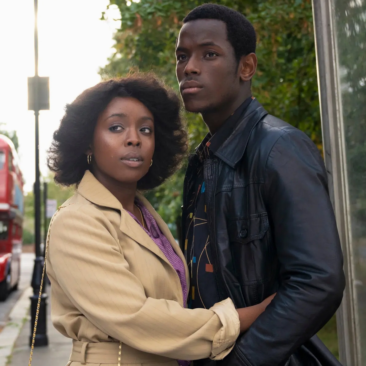 Small Axe Film Still of Couple Hugging on Sidewalk with Red Double Decker Bus in Background, 2020, Steve McQueen, Director
