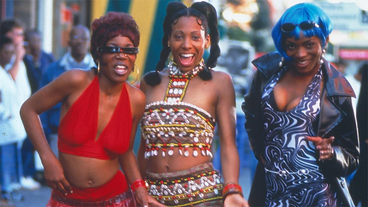 Babymother Film Still, Three Colorfully Dressed Happy Women on Sidewalk