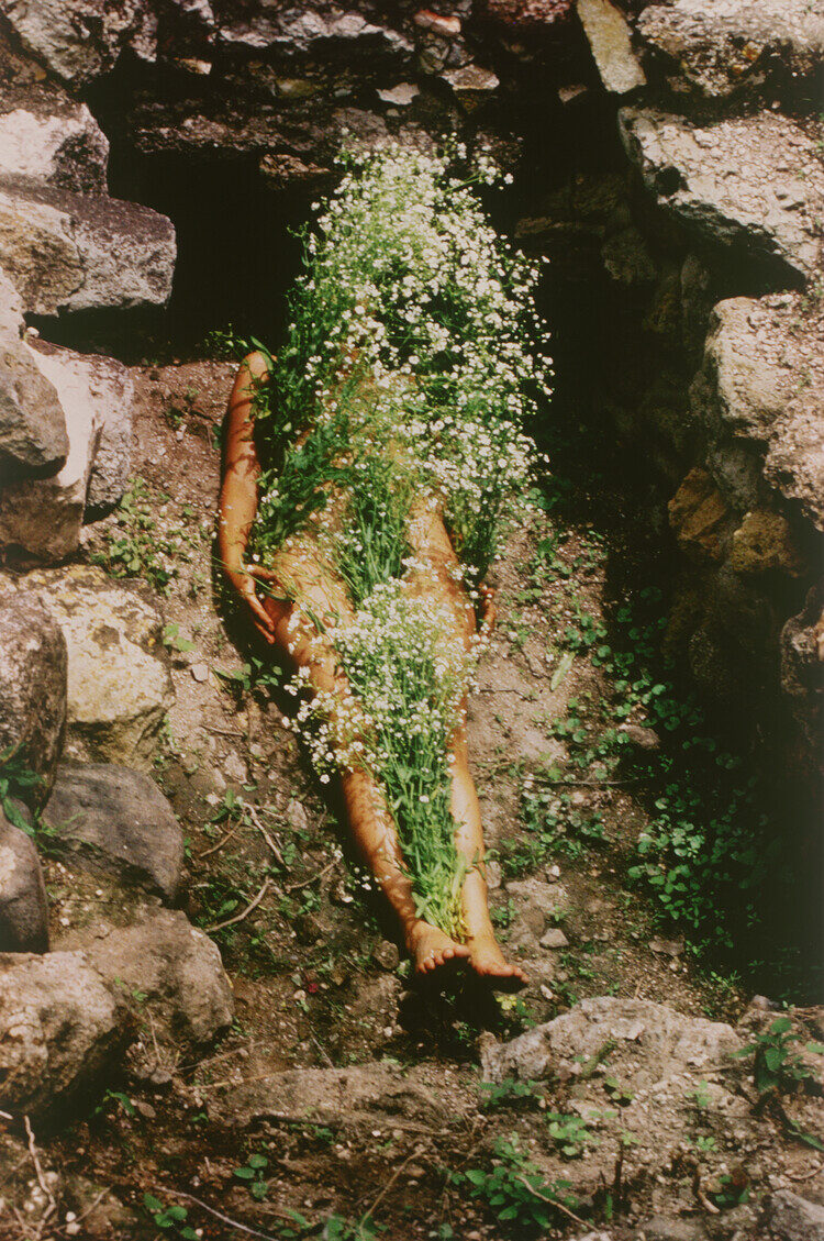(Nude Woman Covered in White Flowers in a Shallow Rock Pit) by Ana Mendieta, Imagen de Yagul, from the Series Silueta Works in Mexico 1973-1977, 1973