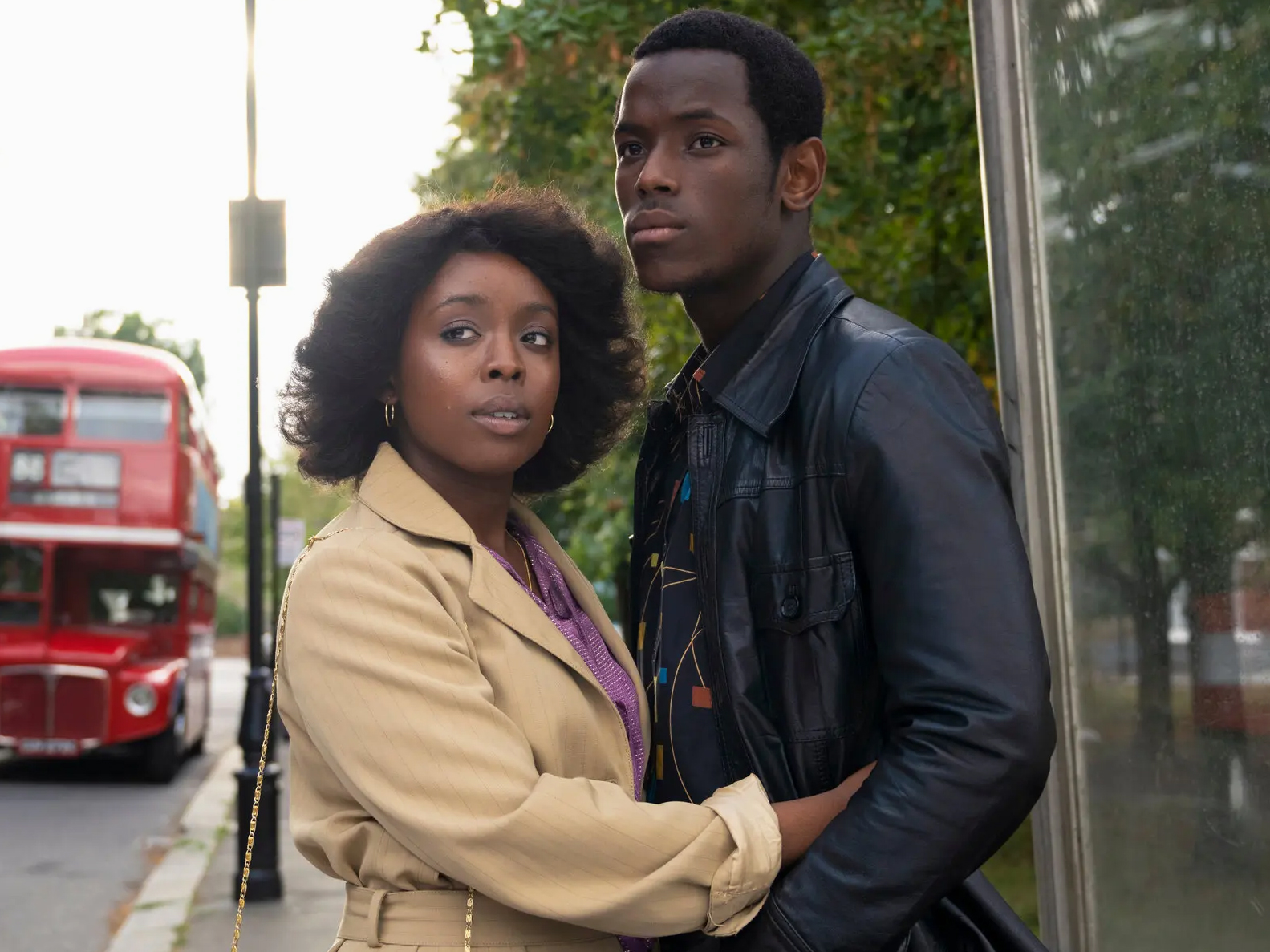 Small Axe Film Still of Couple Hugging on Sidewalk with Red Double Decker Bus in Background, 2020, Steve McQueen, Director